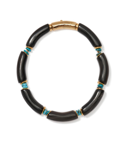 The Cathedral Collar by Lizzie Fortunato is a black horn beads necklace with curved segments, small turquoise stones, gold accents, and a gold clasp.