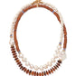 The Cabana Necklace by Lizzie Fortunato showcases two strands—one with white and brown beads, the other with pearls, amber discs, and blue accents—finished with a gold clasp. A statement piece to elevate any outfit.