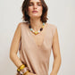 A woman with shoulder-length brown hair wears a sleeveless beige dress and the Lizzie Fortunato Mistflower Necklace, seated against a plain light background.