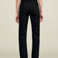 A person stands facing away, wearing a sleeveless striped top and the Kallmeyer Farah Classic Bootcut high-waisted black jeans with back pockets, crafted from stretch cotton denim, against a plain light background.