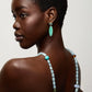 A woman with short hair wears a beaded necklace and the striking Valery Earrings by Lizzie Fortunato, looking over her shoulder against a plain background.