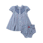 Presenting the Baby Girls’ Lucia Dress Set from Pink Chicken: a charming light blue baby dress featuring short puff sleeves and a matching pair of bloomers, both adorned with a petite floral print and an elegant blue smocked collar. Intricate diamond smocking highlights heritage craftsmanship, making this Pink Chicken set a timeless addition to your little one’s wardrobe.