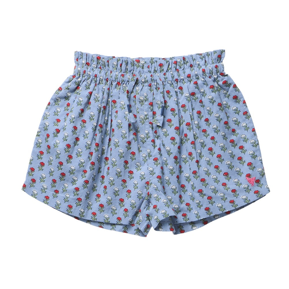 Girls’ Theodore Short by Pink Chicken in light blue, styled with an elastic waist and adorned with a delightful blockprint pattern of small red and white flowers with green leaves.
