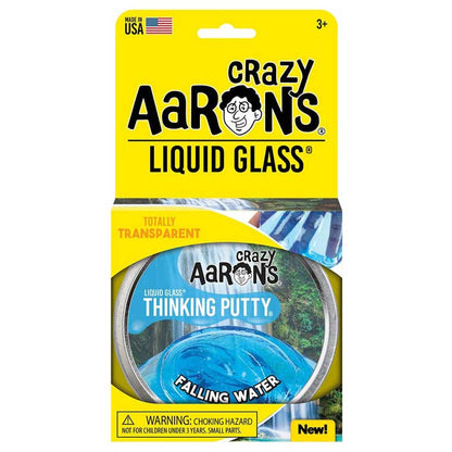 Packaging of Crazy Aaron's Liquid Glass Thinking Putty from Crazy Aarons in the Falling Water variant. This product, made from non-toxic silicone, is labeled "Totally Transparent" and designed for ages 3 and up. Ideal for sensory integration, it is proudly made in the USA. Warning: choking hazard.