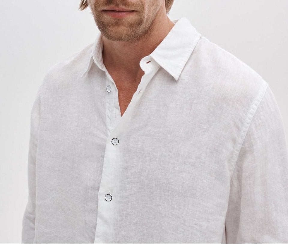 A man models the Rag & Bone Finch Linen Shirt—a relaxed fit, long sleeve linen piece—standing against a plain, light background with his face partially out of frame.