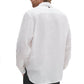A person is shown from the back against a plain background wearing the Rag & Bone Finch Linen Shirt, a relaxed fit white long sleeve shirt.