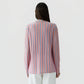A person with long brown hair is seen from behind wearing the Guest in Residence Fine Stripe Showtime Shirt, featuring relaxed fit stripes in pink, blue, and purple tones, paired with white pants against a plain background.