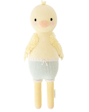 Finley the Duckling - Little 13" by Cuddle + Kind is a knitted yellow plush toy, designed with a round head, pink cheeks, short wings, and blue-and-white striped shorts topped with a decorative bow—making it an adorable birthday gift for any child.