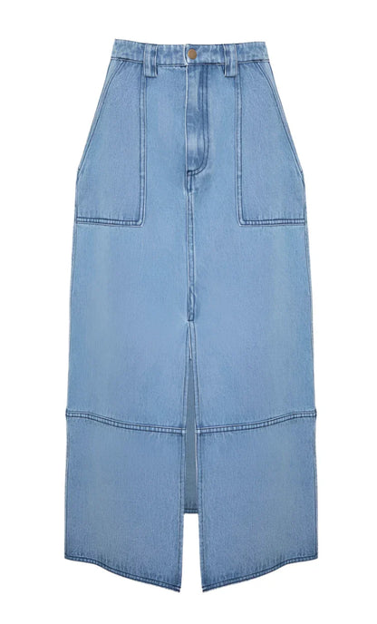 The Parke Skirt by Hunter Bell NYC is a light blue midi denim skirt with a stylish front seam and slit, featuring two large front pockets and a waistband with button closure.