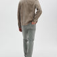 A man faces away against a white background, wearing a taupe suede jacket, Rag & Bone Fit 2 Aero Stretch Denim light gray pants, and black shoes.
