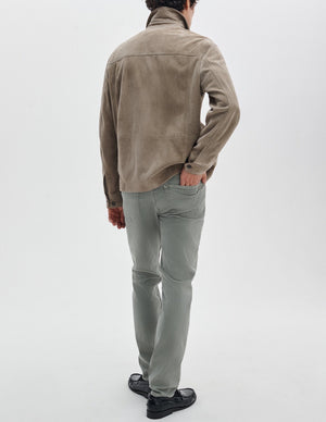 A man faces away against a white background, wearing a taupe suede jacket, Rag & Bone Fit 2 Aero Stretch Denim light gray pants, and black shoes.