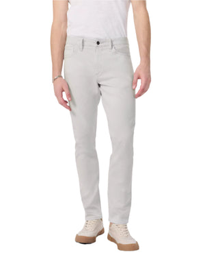 A person wearing Rag & Bone Fit 3 Aero Stretch Athletic Jeans in light gray, a white t-shirt, and beige sneakers stands against a plain white background.
