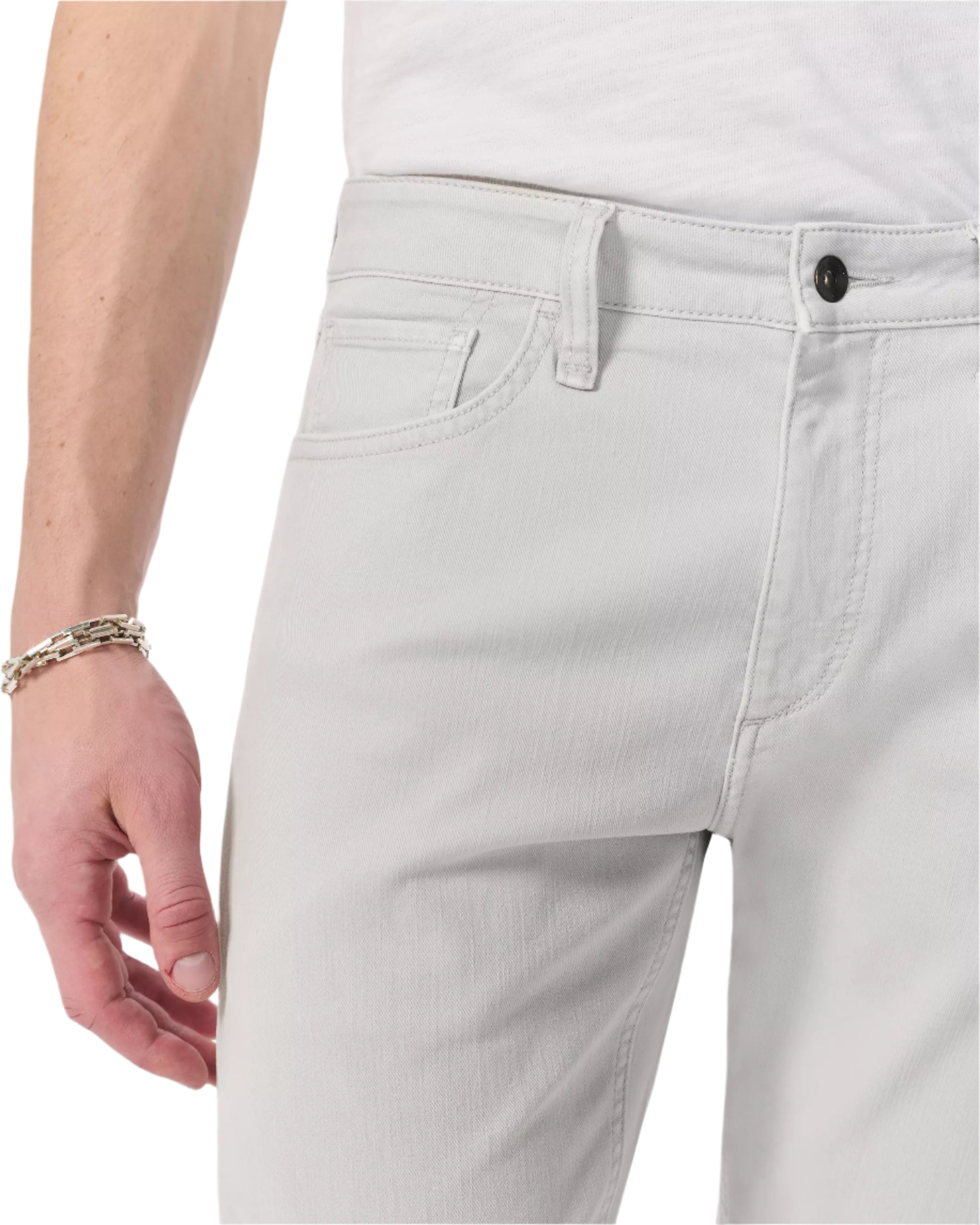 A person wearing Rag & Bone Fit 3 Aero Stretch Athletic Jeans in light gray and a white shirt, with a silver bracelet on their left wrist.
