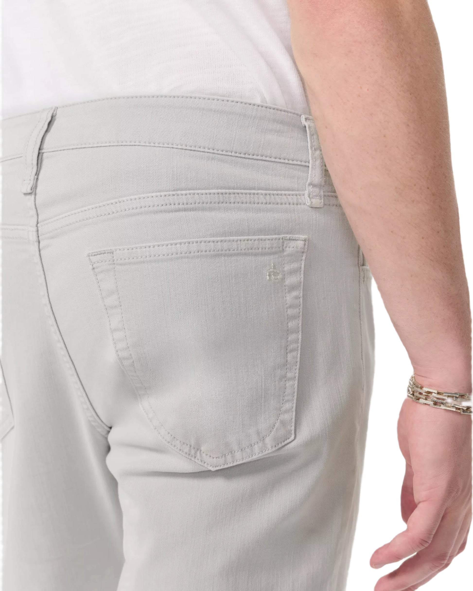 Wearing Rag & Bone Fit 3 Aero Stretch Athletic Jeans in light gray with an athletic fit, paired with a white shirt; the back pocket and right arm with a silver bracelet are visible.