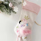 Introducing the Mon Ami Festive Flamingo Stocking: This delightful pink stocking, adorned with a regal flamingo embroidered with a gold crown, is beautifully decorated with colorful Christmas lights and intricate designs. It makes for a charming festive decoration when hung among evergreen branches, delicate snowflakes, and baubles.