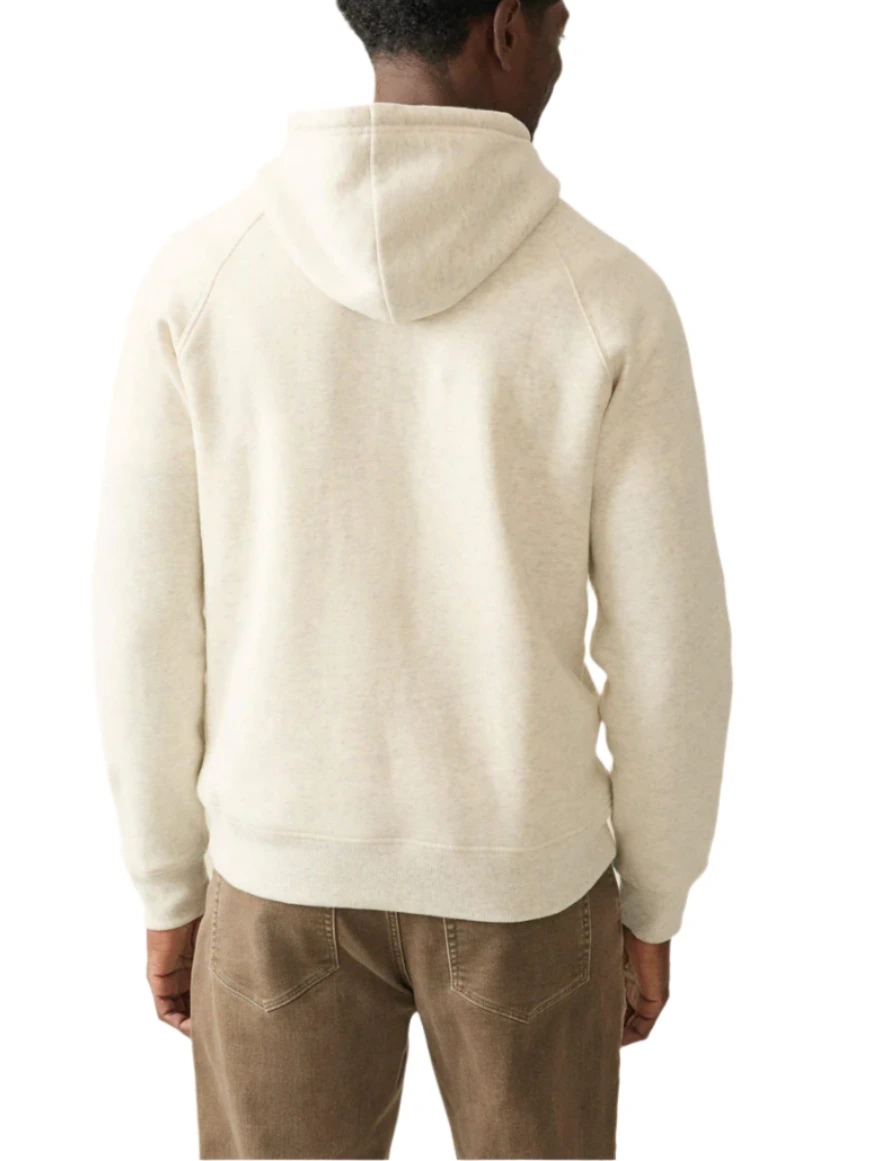 A person is seen from the back wearing a Faherty High Standard Fleece Hoodie in light gray paired with brown pants, echoing vintage athletic wear.