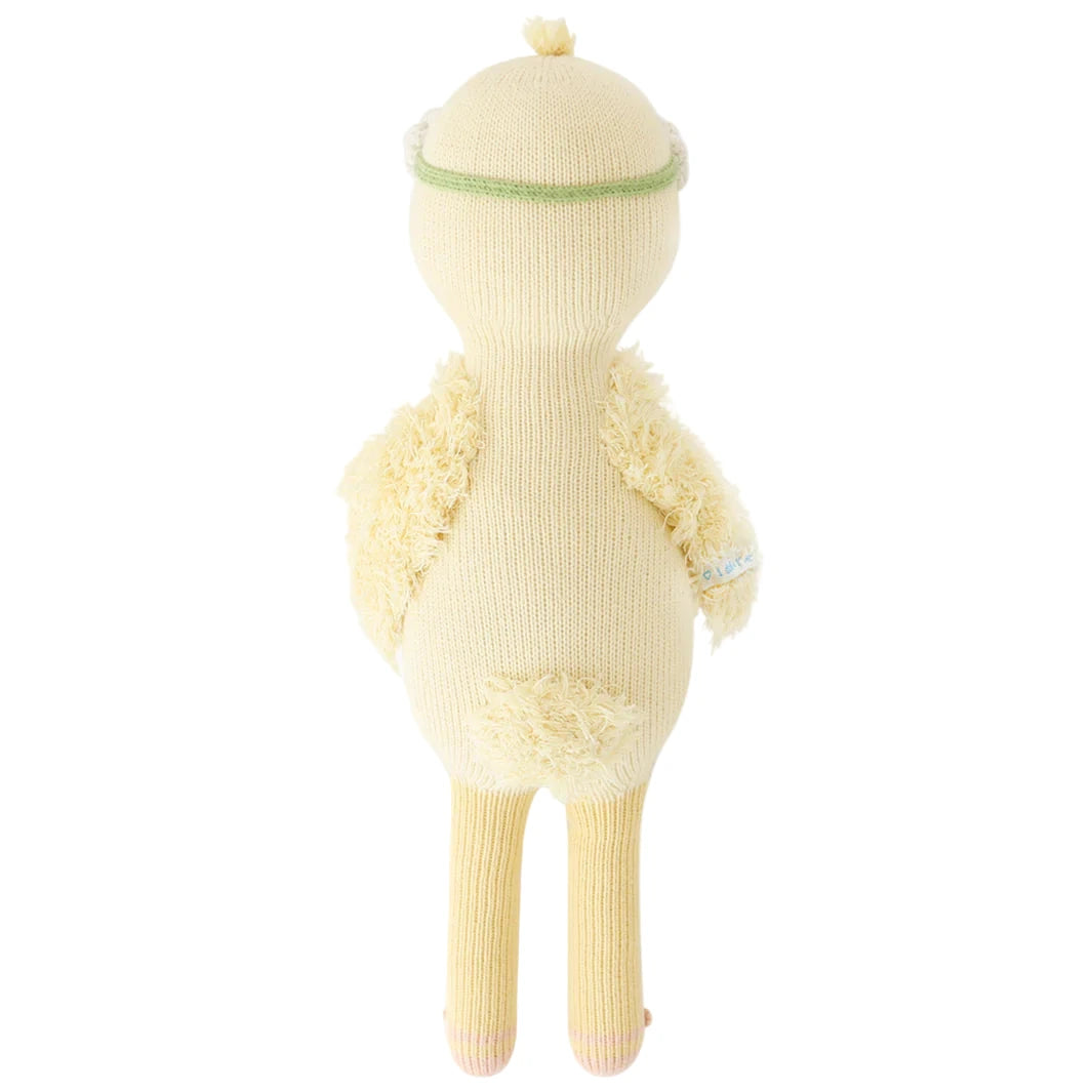 Flora the Duckling Ivory (Little 13") by Cuddle + Kind stands upright, facing away, with wings and tail visible—ready for new adventures among wildflowers.