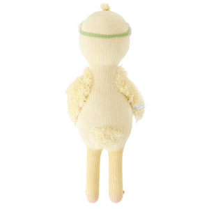 Cuddle + Kind’s Flora the Duckling Ivory (Regular 20”) is a plush yellow stuffed animal with a round body, two long legs, and a small tail, seen from behind as if about to dance among wildflowers.