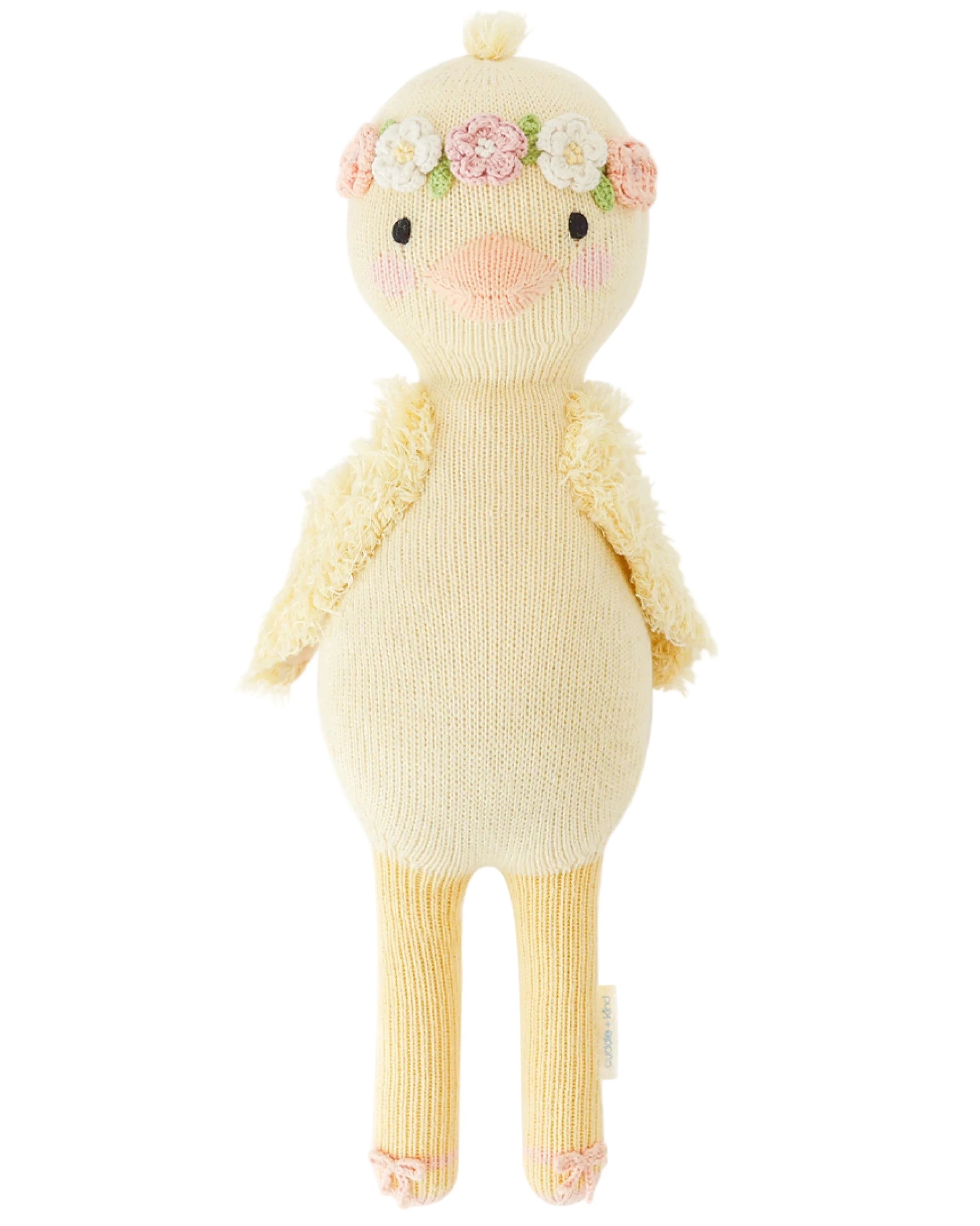 Flora the Duckling Mauve - Little 13" by Cuddle + Kind is a knitted plush yellow duck with a floral headband and textured wings, posed upright against a white background.