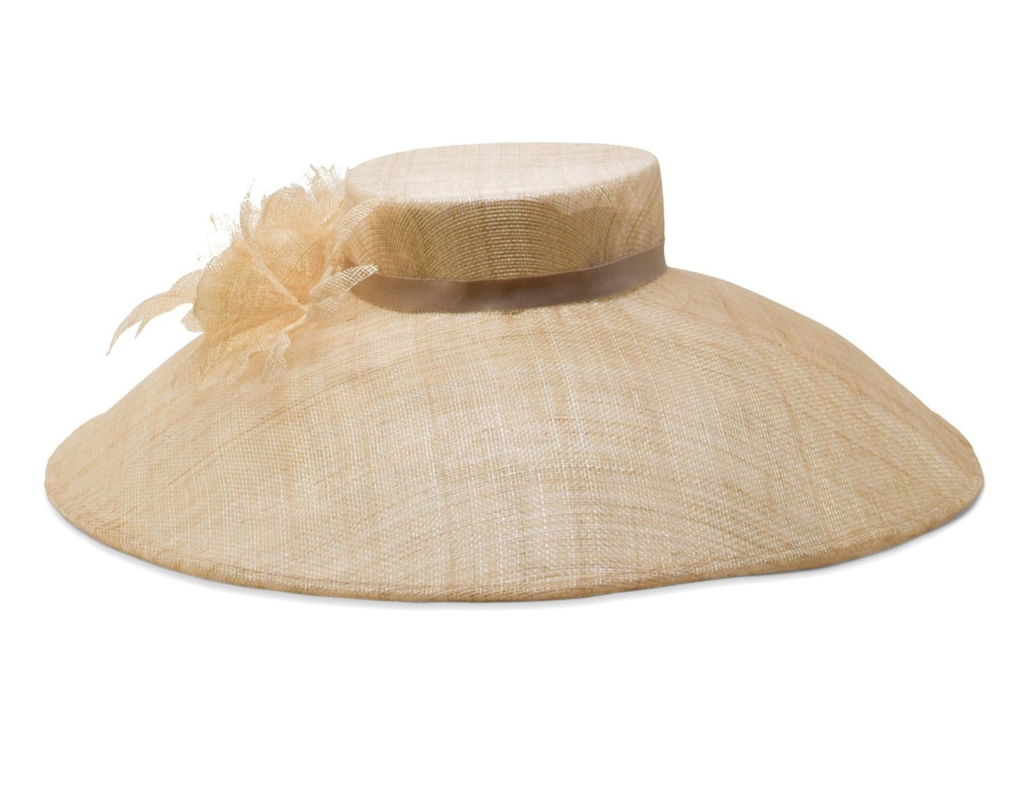 The Gigi Burris Flora Sinamay Hat, a handcrafted wide-brimmed beige straw hat from Gigi Burris, features a ribbon and a decorative feather accent on the side, highlighting the exquisite art of millinery.