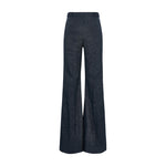 The Fluid Denim Pants by Dorothee Schumacher feature a high-waisted, wide-leg silhouette in dark denim with braided waistband detailing, evoking vintage suiting style, shown against a white background.