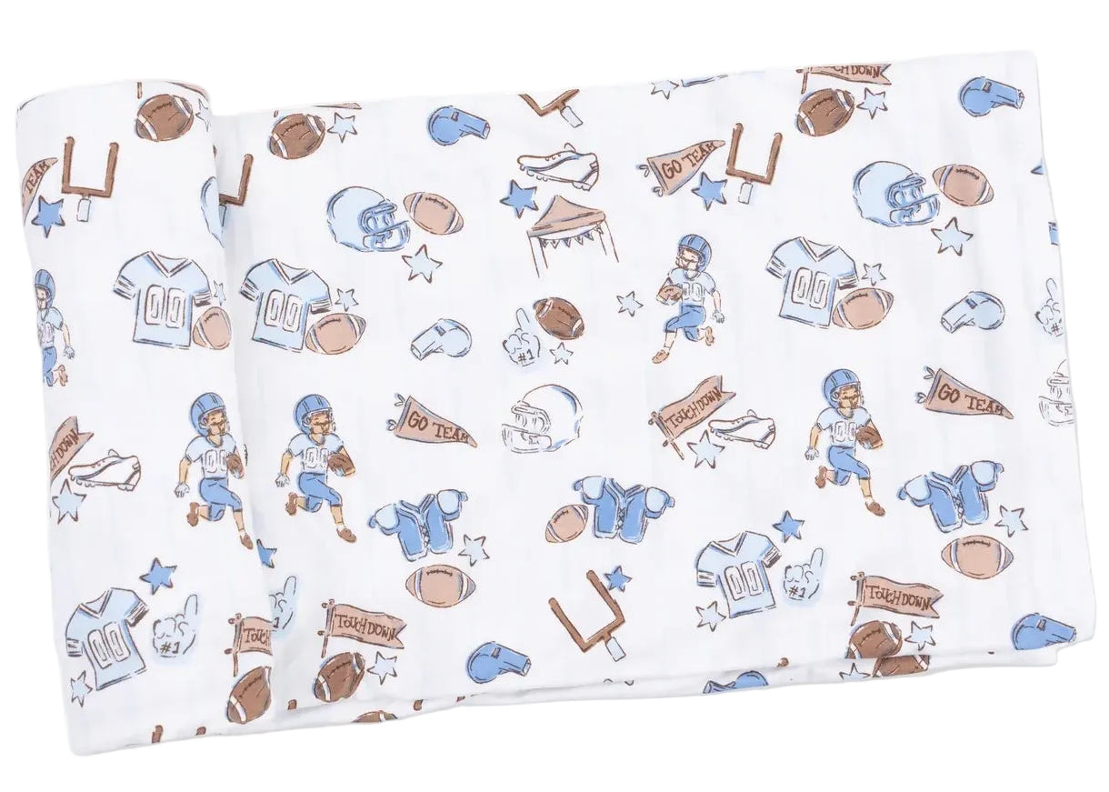 Soft white Swaddle Blanket by Angel Dear featuring a playful pattern of blue and brown football-themed illustrations—jerseys, helmets, footballs, players, and megaphones—crafted from gentle viscose from bamboo. Perfect for keeping your baby cozy.