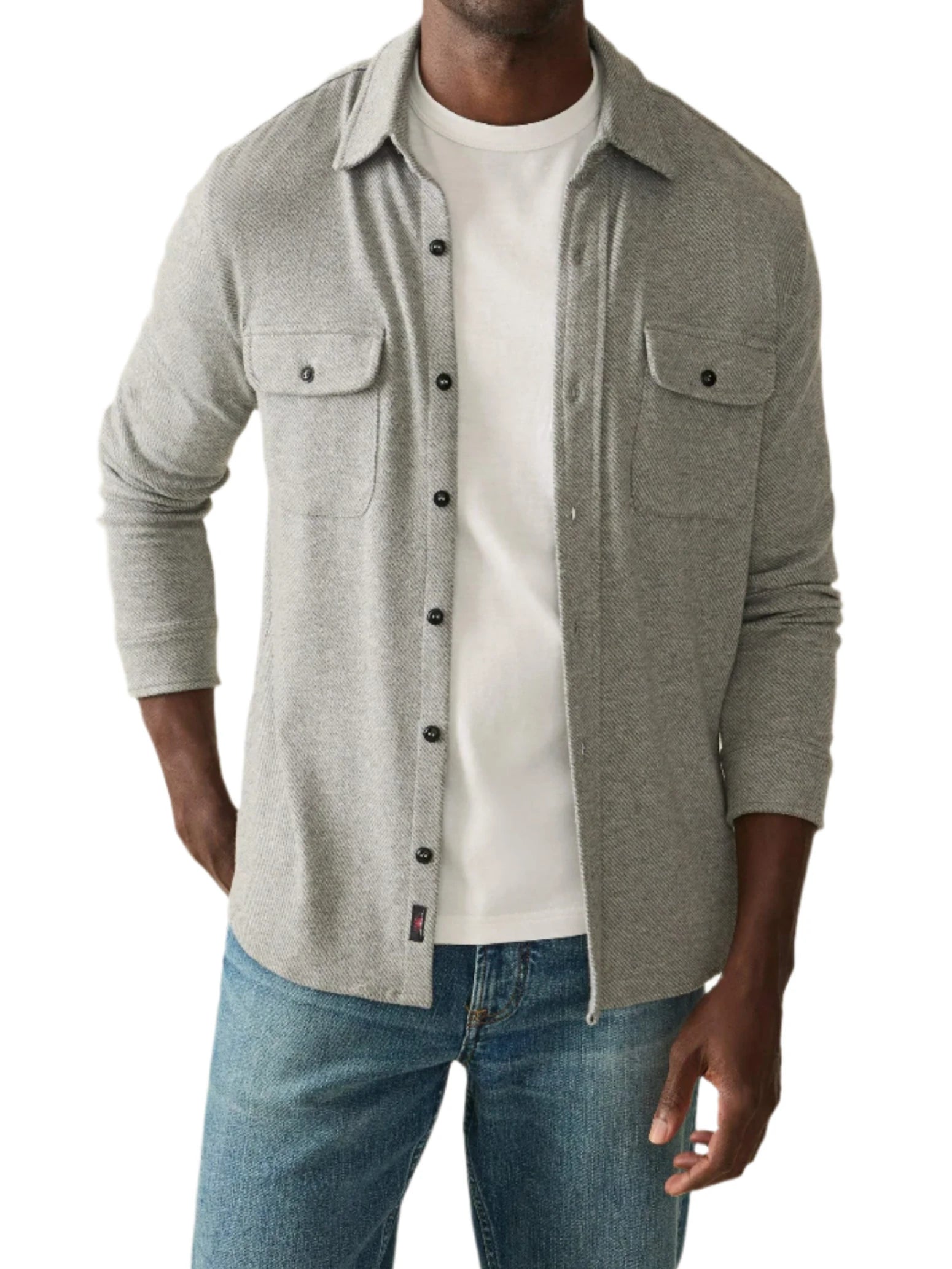 A person wearing the bestselling Faherty Legend™ Sweater Shirt in light gray over a white t-shirt and blue jeans stands against a plain background.