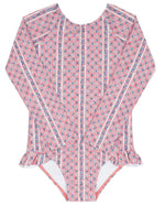 The Minnow Girls' Floral Tile Rashguard One Piece features pink long sleeves, a small floral tile print, vertical white stripes, and hip ruffles for stylish, sun-safe swimwear.