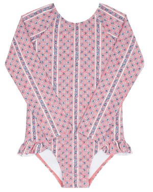 The Minnow Girls' Floral Tile Rashguard One Piece features pink long sleeves, a small floral tile print, vertical white stripes, and hip ruffles for stylish, sun-safe swimwear.