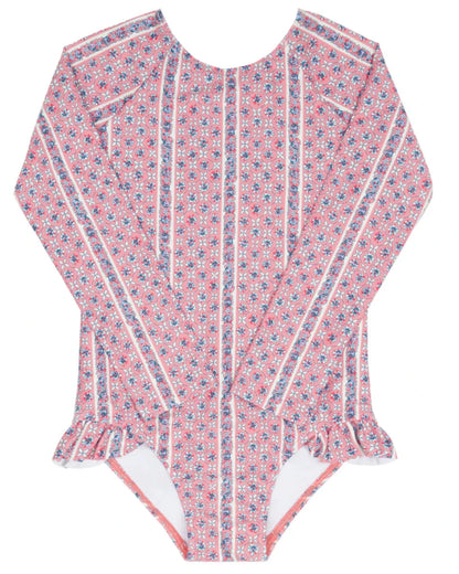 The Minnow Girls' Floral Tile Rashguard One Piece features pink long sleeves, a small floral tile print, vertical white stripes, and hip ruffles for stylish, sun-safe swimwear.