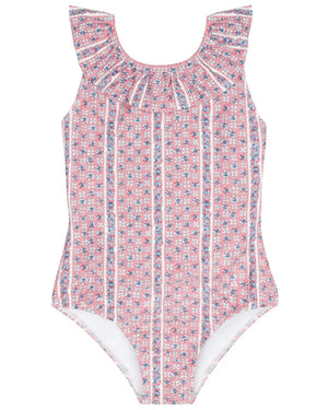 The Minnow Girls' Floral Tile Ruffle Collar One Piece features a pink floral tile print, white vertical stripes, and a charming ruffled neckline, shown on a plain background.