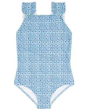 The Minnow Girls' Starburst Ruffle Strap One Piece features a blue geometric pattern, square neck, and ruffled shoulder straps, shown on a plain white background.