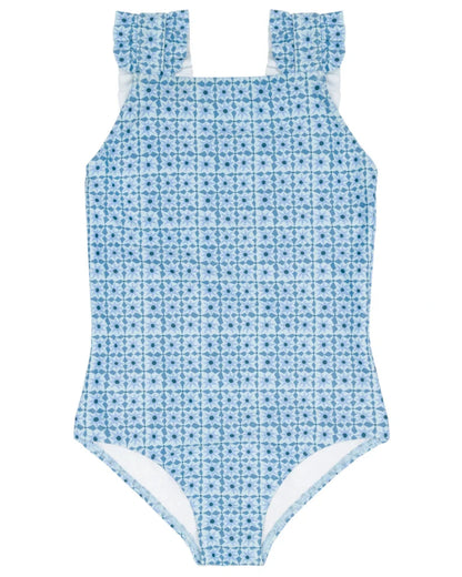 The Minnow Girls' Starburst Ruffle Strap One Piece features a blue geometric pattern, square neck, and ruffled shoulder straps, shown on a plain white background.