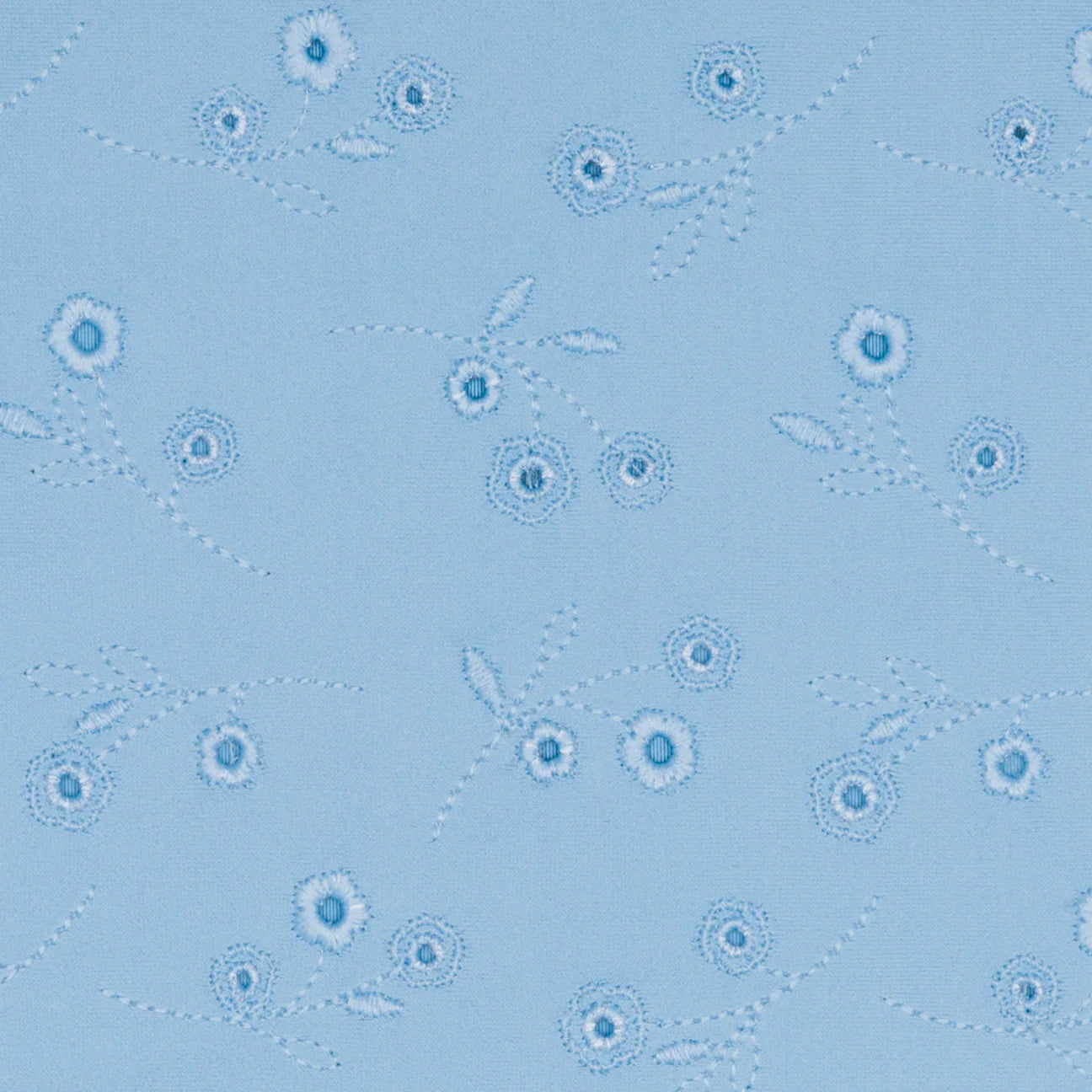 The Minnow Girls' Eyelet Rashguard One Piece features light blue, sun-safe fabric with embroidered small blue flowers and stems, and a charming ruffle hip detail.