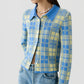 Woman wearing the Fringe Plaid Elle Shirt by Guest in Residence—a blue and yellow plaid button-up with a large collar—paired with light blue jeans and finished with a shell necklace for a touch of Western-inspired style.