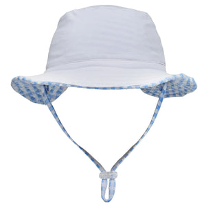 The Snapper Rock Seaside Gingham Reversible Bucket Hat is a light blue kids' hat with a chin strap and blue-and-white checkered brim lining. UPF50+ for sun safety, it's perfect for all outdoor adventures. Shown on a white background.