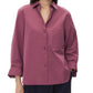 A person wearing the TWP Next Morning Shirt—an oversized mauve button-down with long sleeves, a left chest pocket, and a relaxed silhouette—paired with dark trousers.
