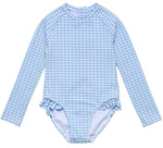 The Girls' Seaside Gingham Leg Frill Surf Suit by Snapper Rock is a long-sleeve one-piece with light blue and white checks, leg ruffles, and UPF50+ sun protection.