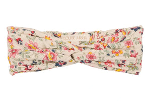 The Julie Headband by Louise Misha is a floral-patterned cotton batiste turban headband with a stylish front twist and signature label.