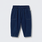 A pair of Cozmo Baby Galo Denim Pants for children, featuring a dark blue herringbone twill, elastic waistband, and two front pockets, displayed against a plain white background.