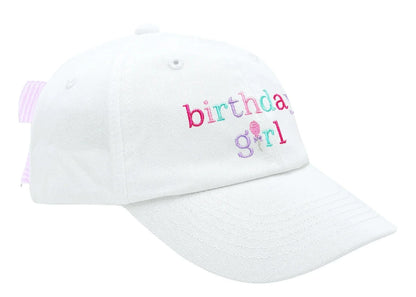 The Birthday Girl Bow Baseball Hat by Bits & Bows features "birthday girl" embroidered in colorful letters, a pink-striped adjustable strap, and a seersucker bow at the back.