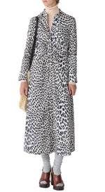 A person wearing the Callas Milano Genny Cheetah Shirtdress styled with a beige turtleneck, gray socks, brown sandals, and a cream shoulder bag.