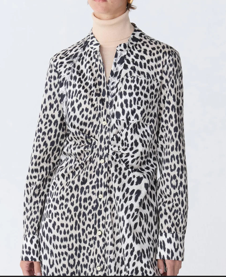 A person wearing the Genny Cheetah Shirtdress by Callas Milano over a beige turtleneck top.