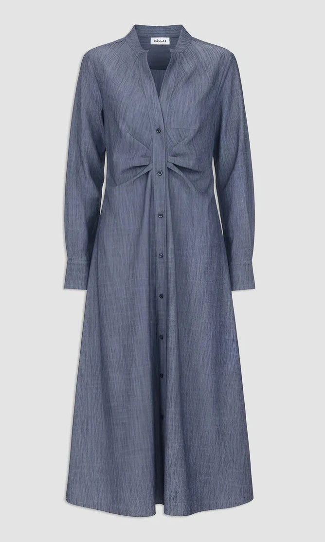 The Genny Dress by Callas Milano is a gray chambray long sleeve button-front dress with a fit and flare silhouette and gathered waist, inspired by Italian shirting twill for timeless style.