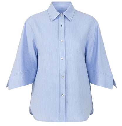 The Georgie Top by Callas Milano is a light blue classic shirt made from Italian twill, featuring a point collar and wide three-quarter sleeves, shown on a plain white background.