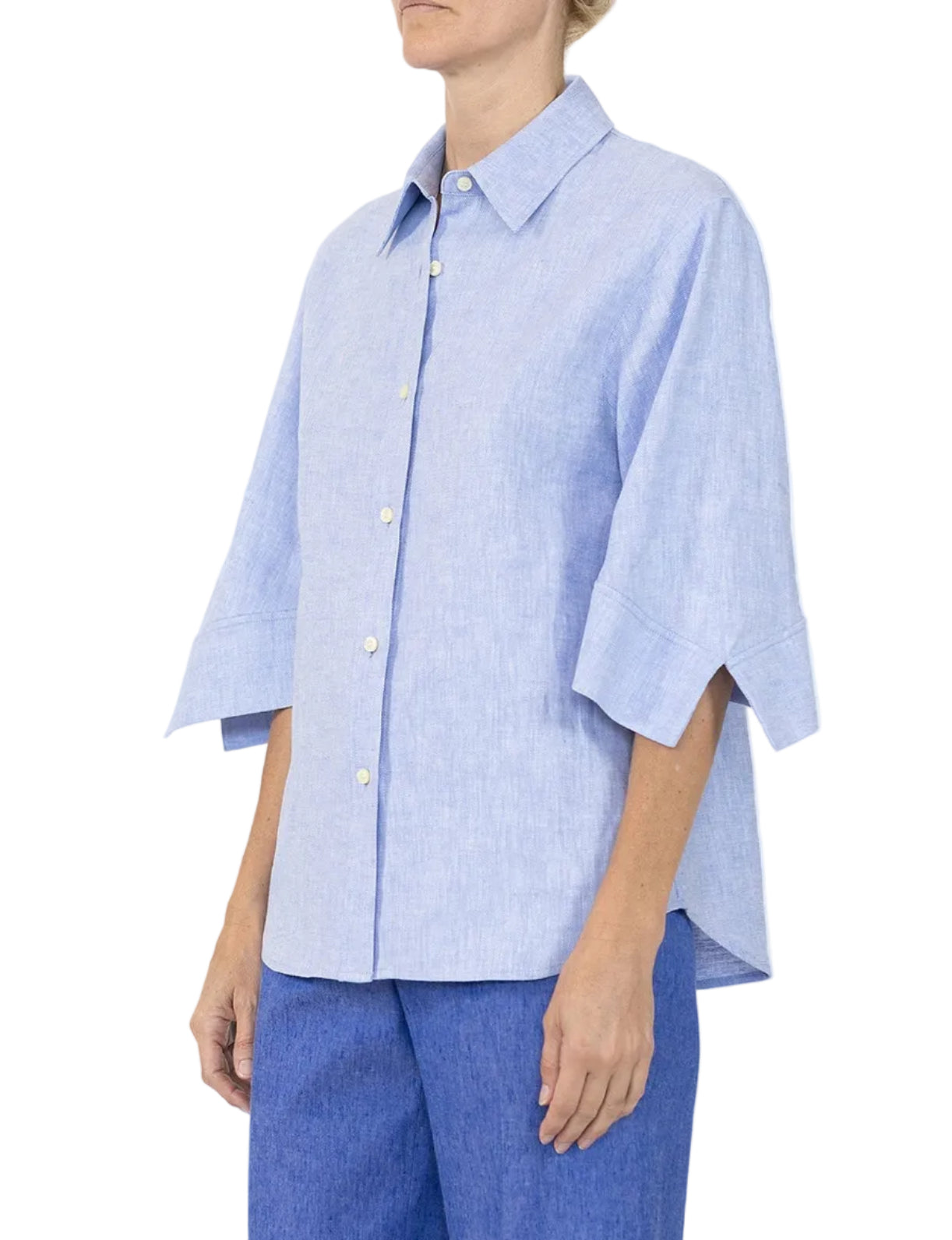 A person wears the Callas Milano Georgie Top in light blue Italian twill with a point collar and three-quarter sleeves, paired with blue pants, standing against a plain background.