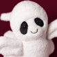 A Jellycat Ghost Bob plush toy, featuring black oval eyes and a small smile, is displayed against a dark red background.