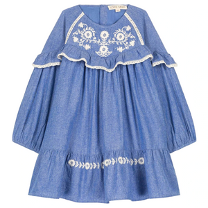 The Louise Misha Girls' Orana Dress features blue cotton chambray, white floral embroidery, lace trim, ruffled chest detail, and a flared hem.