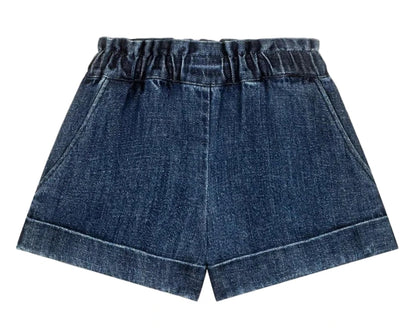 The Girls' Virgina Shorts by Louise Misha are dark blue denim with an elastic waist, side pockets, and a wide fit, shown against a white background.