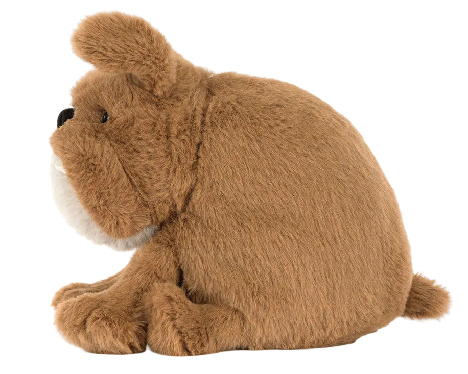 A Jellycat Derreck Dog plush toy, shaped like a friendly bulldog postie, is displayed in profile view against a white background.